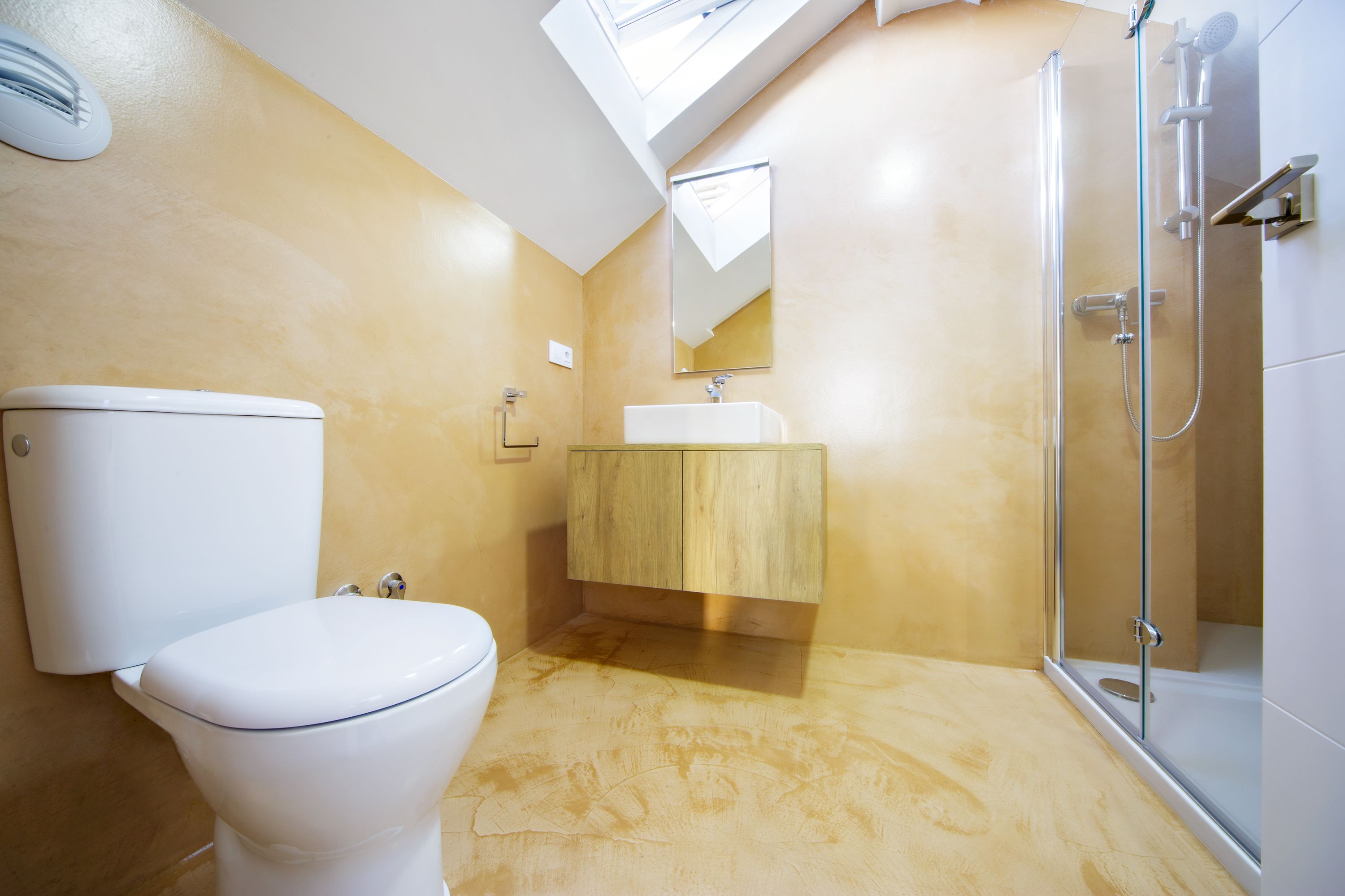 Une salle de bain avec des toilettes, un lavabo et une douche.