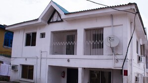 Un bâtiment à deux étages, doté de fenêtres grillagées, d’une antenne parabolique et d’un extincteur.