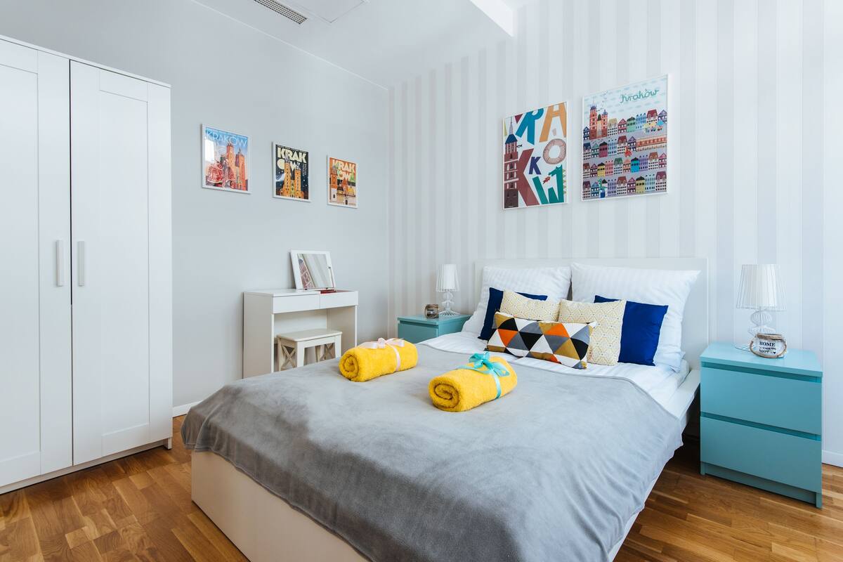 Une chambre à coucher moderne, avec un lit, des tables de chevet et des œuvres d’art accrochées aux murs.