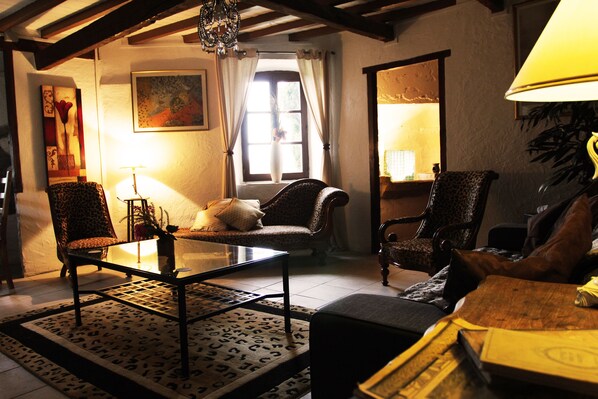 A cozy living room with a sofa, armchairs, a coffee table, and a patterned rug.