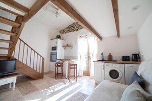 A cozy living room with a staircase, a kitchen area, and a laundry room. - Domaine de Palatz (Laure-Minervois)