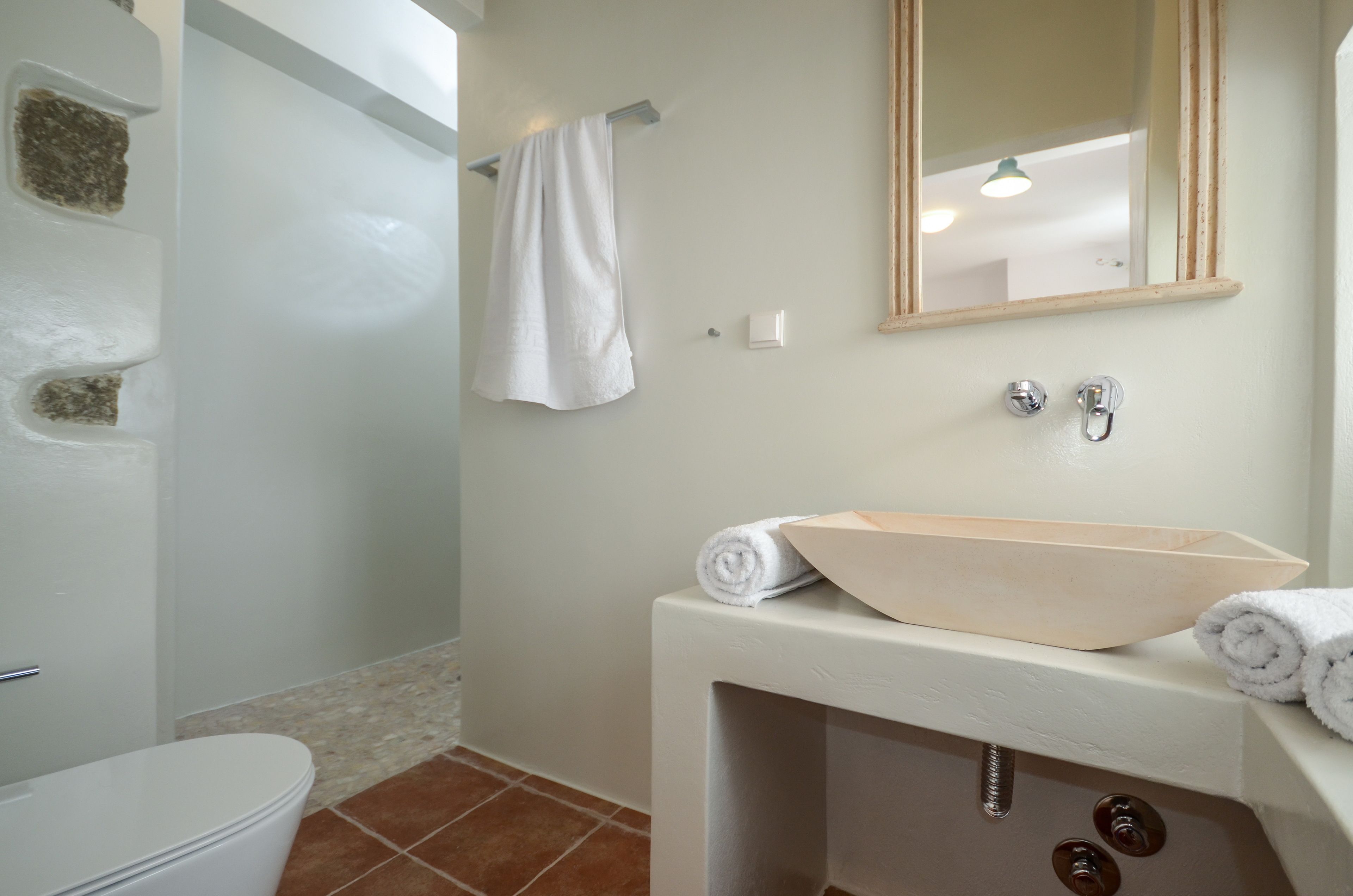Une salle de bain avec un lavabo blanc, un miroir et une serviette accrochée au mur.