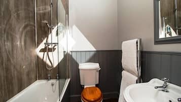 Un baño con bañera, inodoro y lavamanos.