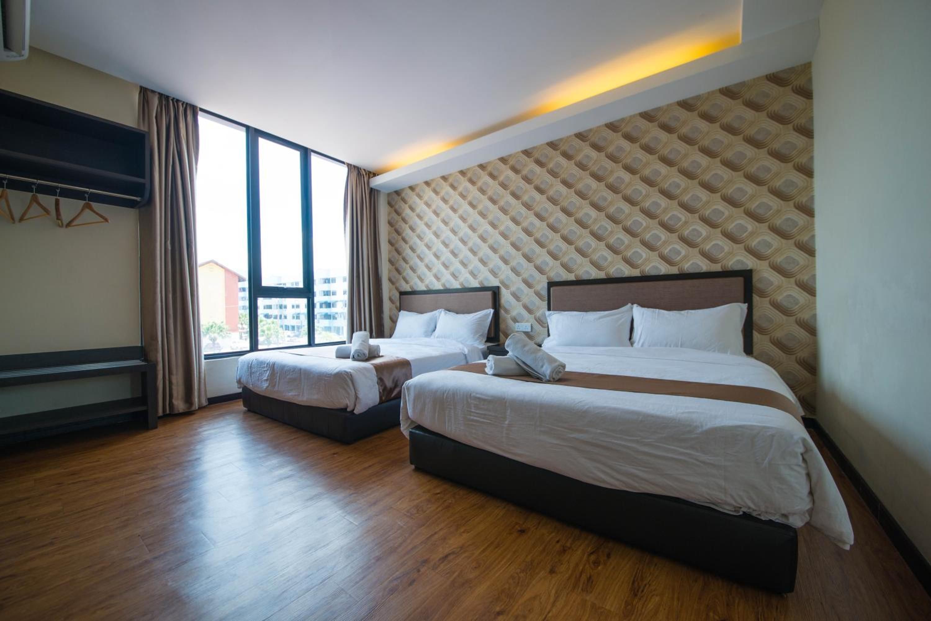 A hotel room with two beds, a large window, and a patterned wall.