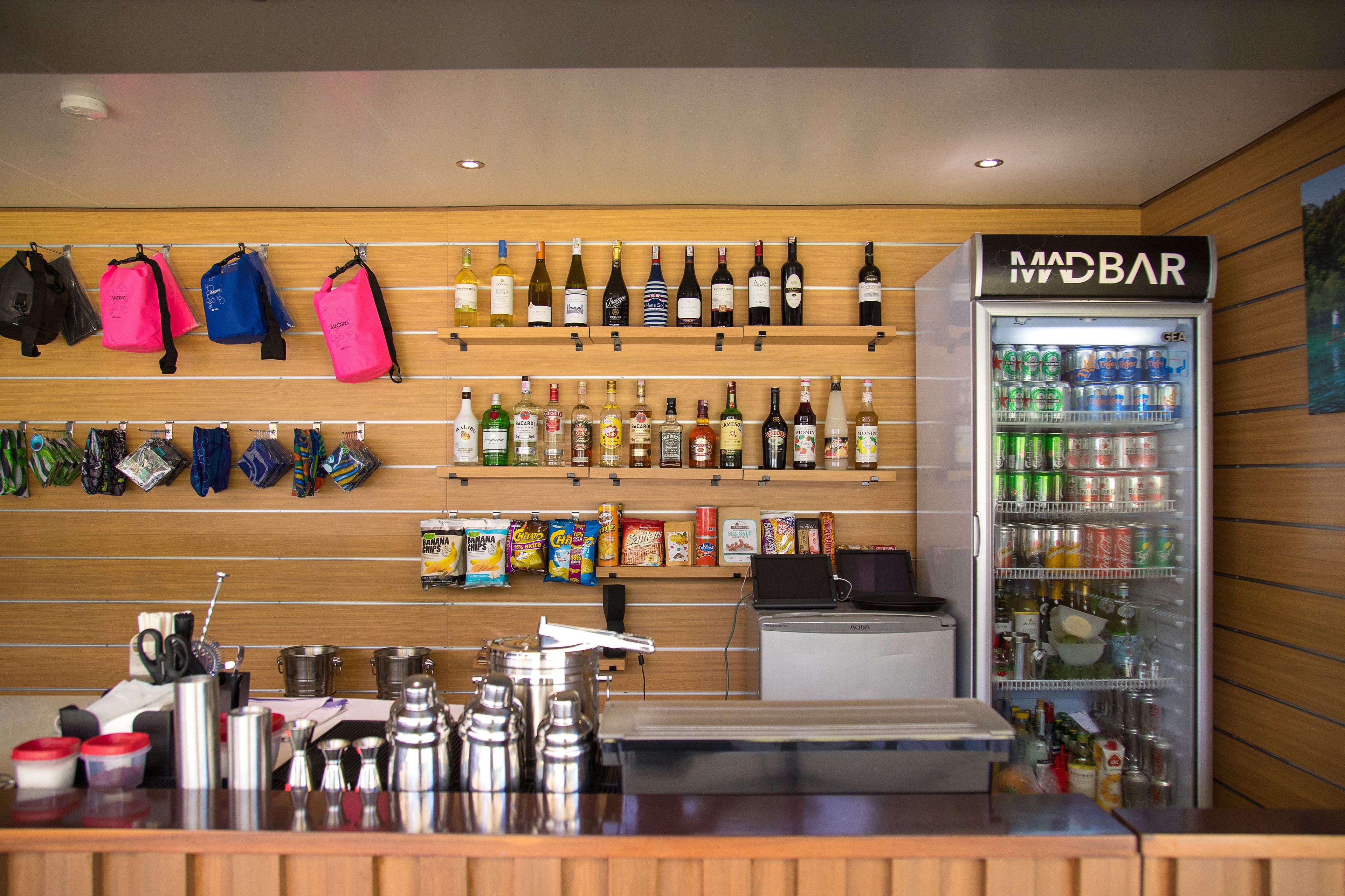 Una zona de bar con una cava de vinos, bolsas de aperitivos y un dispensador de bebidas.
