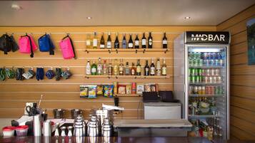 Una zona de bar con una cava de vinos, bolsas de aperitivos y un dispensador de bebidas.