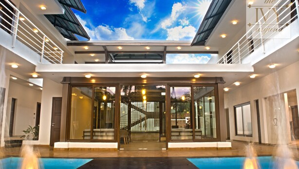 A modern building with a glass atrium, a pool, and a staircase. - The Ivy Anjuna (Anjuna)