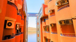 Un pasillo con balcones, unidades de aire acondicionado y vistas al paisaje desértico.