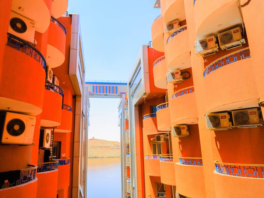 Un pasillo con balcones, unidades de aire acondicionado y vistas al paisaje desértico.
