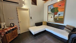 A small, cozy room with a single bed, a wooden cabinet, and a painting on the wall. - Galeria In The Garden (Plovdiv)