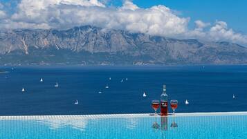 Outdoor pool, an infinity pool, pool umbrellas, pool loungers
