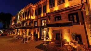 A hotel with outdoor seating, a brick facade, and a sign indicating it is a hotel. - Armistis Hotel (Mudanya)