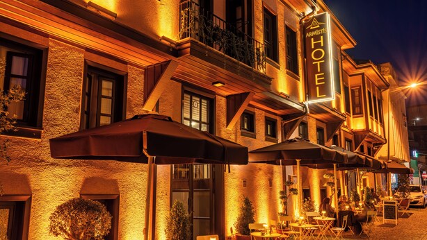 A hotel with outdoor seating, a signboard, and a staircase leading to the entrance. - Armistis Hotel (Mudanya)