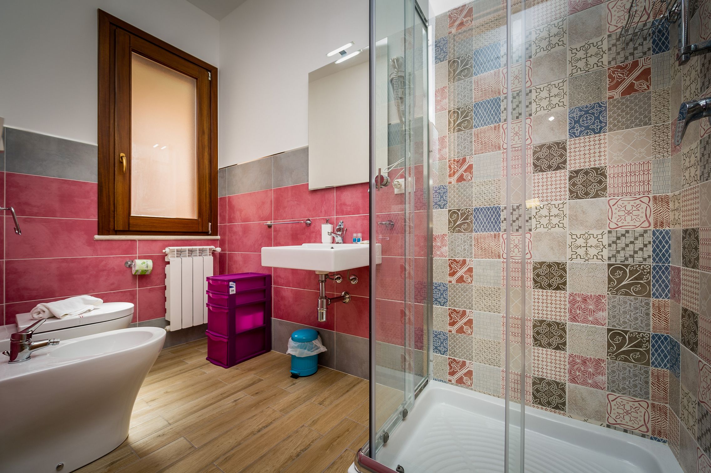Ein Badezimmer mit einer Badewanne, einem Waschbecken, einer Duschkabine aus Glas und einer Toilette.