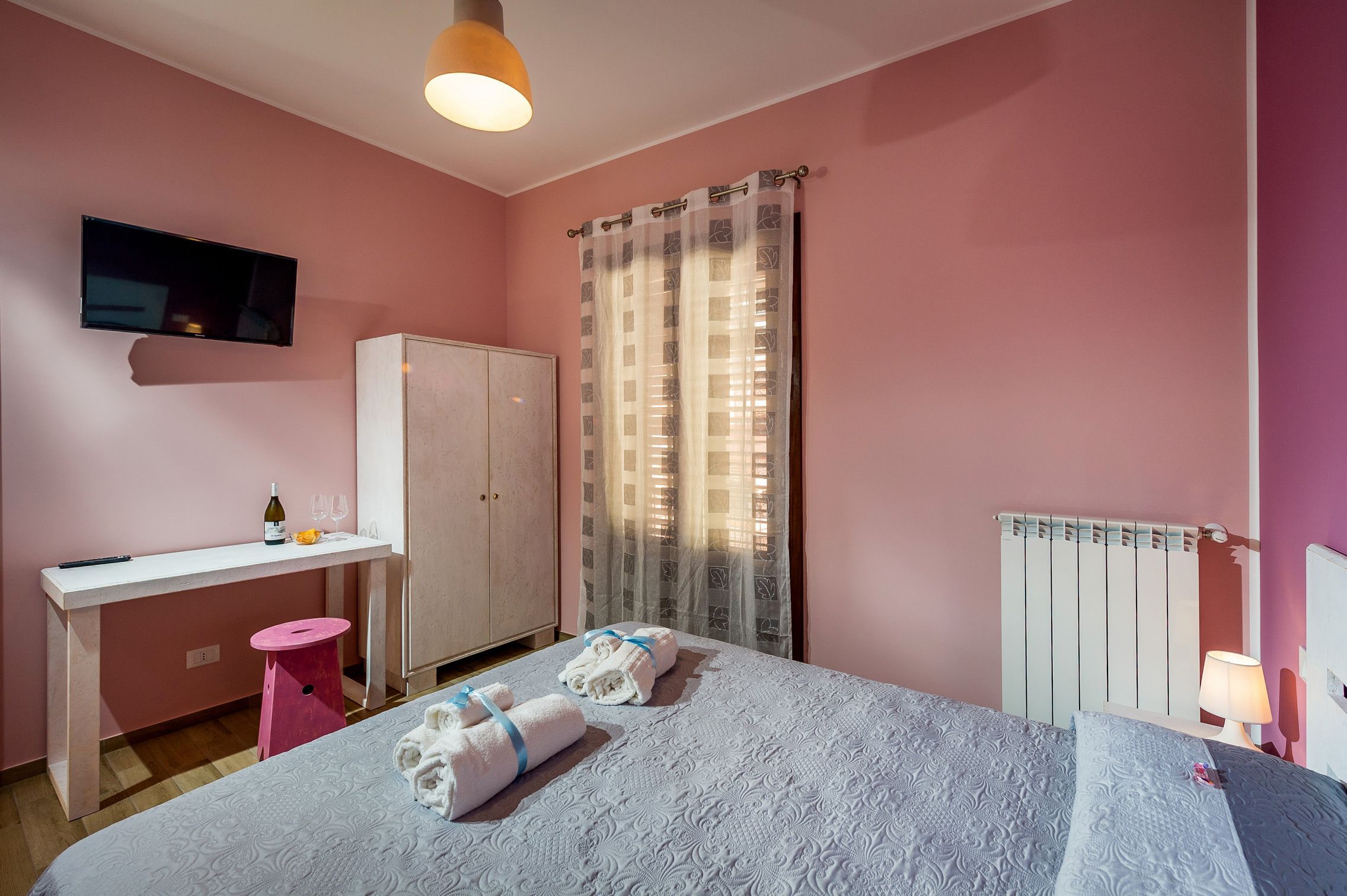 Une chambre à coucher avec un lit, un bureau, une armoire et un radiateur.