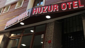 The exterior of the Huzur Hotel with a signboard, large windows, and a tiled facade. - Beyoglu Huzur Hotel (Istanbul)
