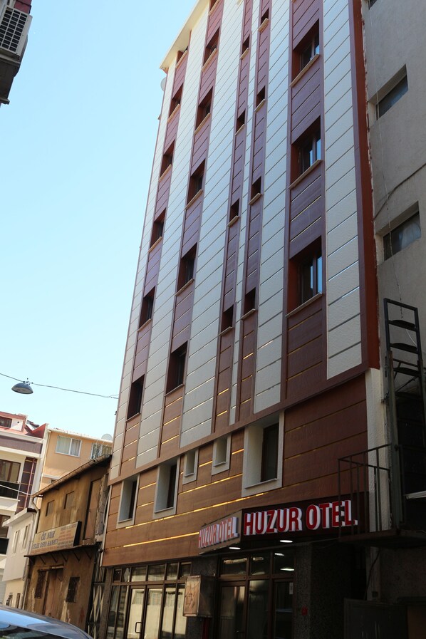 A multi-story building with a sign reading "Huzur Hotel."