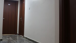 A hallway with dark wooden doors, white walls, and a tiled floor. - Beyoglu Huzur Hotel (Istanbul)