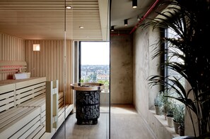 Un spa moderne avec des bancs en bois, un bassin en pierre et des plantes en pot.