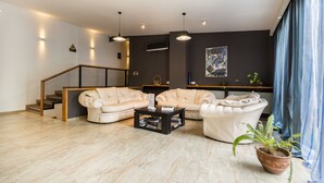 Un salon moderne avec un canapé d’angle, une table basse et une plante en pot.