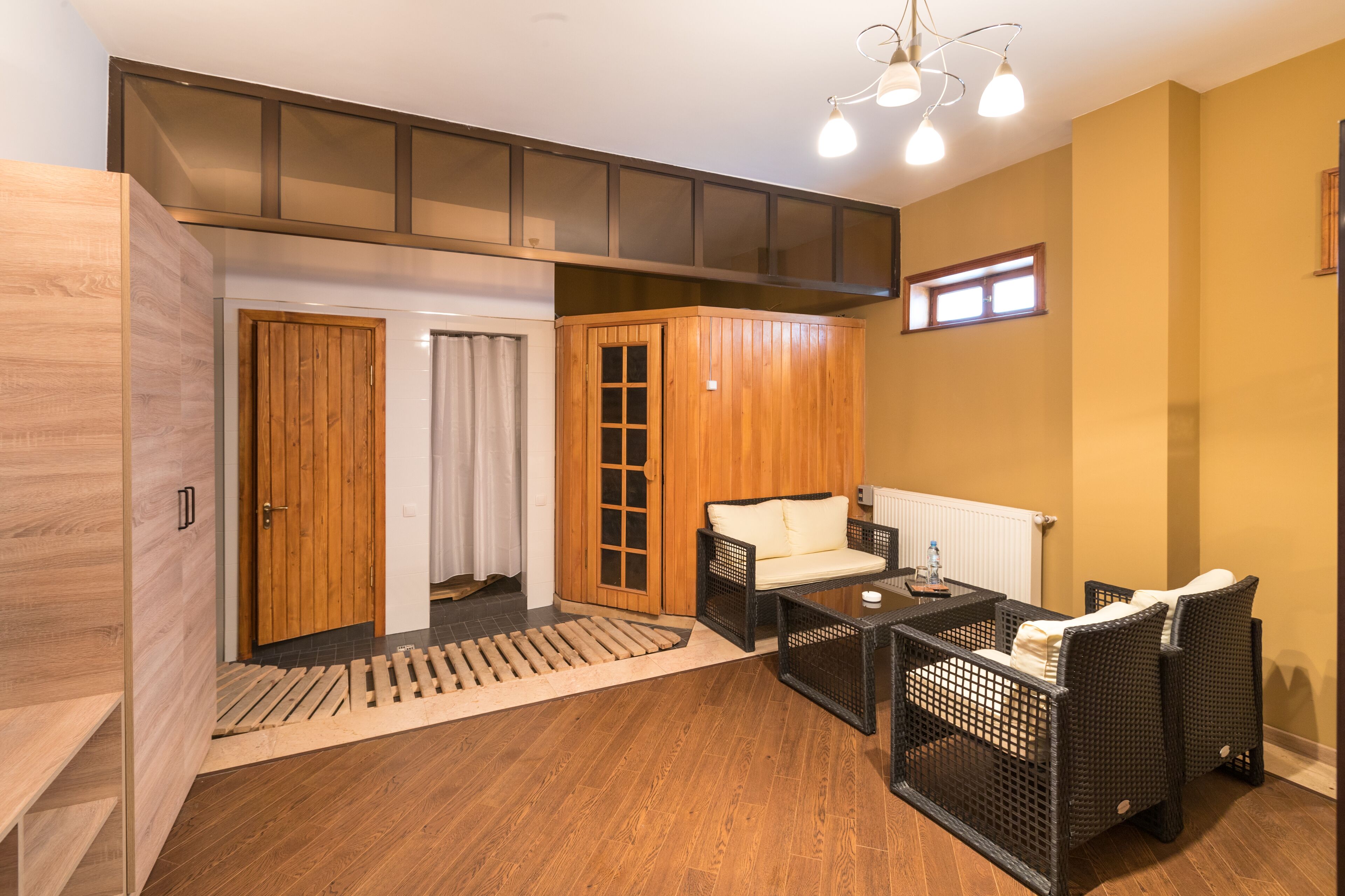 A modern room with a wooden floor, a sofa, a coffee table, and a window with blinds.