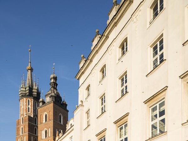 A historic building with a prominent tower and adjacent white facades.