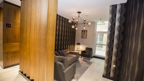 A modern living room with a sofa, armchairs, and a chandelier. - Honour Hotel (Nigde)