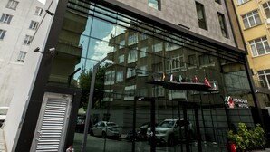 A modern hotel with a glass facade, a prominent entrance, and a sign reading "Honour Hotel". - Honour Hotel (Nigde)