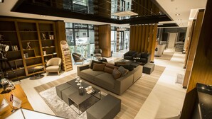 A spacious living area with a modern sofa, a coffee table, and a bookshelf. - Honour Hotel (Nigde)