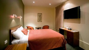 A hotel room with a bed, a desk, a chair, a television, and a small table. - Thamel Trekkers Hotel (Kathmandu)