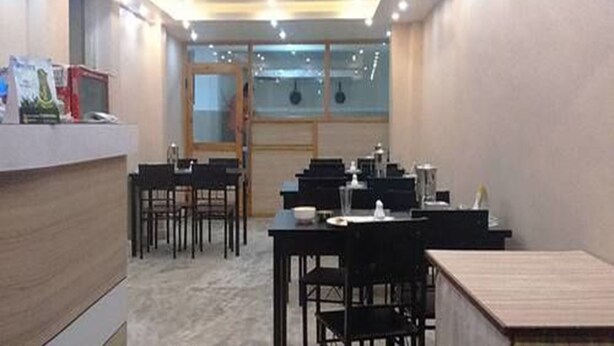 A conference room with tables and chairs, a reception desk, and a large window. - Thamel Trekkers Hotel (Kathmandu)