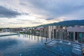 A rooftop infinity pool with a view of a cityscape and mountains in the background. - Stay With Nimman Chiang Mai (Chiang Mai)