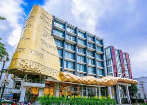 A modern hotel with a unique architectural design, featuring a prominent golden structure and multiple balconies. - Stay With Nimman Chiang Mai (Chiang Mai)