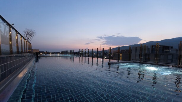 Una piscina d'hidromassatge sense arestes a l'exterior amb una vista clara de les muntanyes al fons.