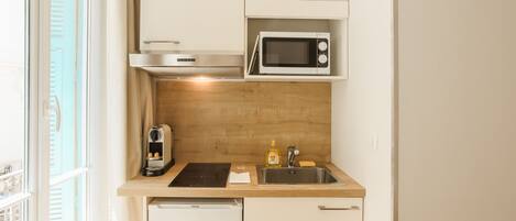 A compact kitchen with a microwave, sink, and a compact dishwasher.