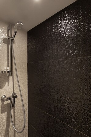 Deluxe studio | Badkamer | Een douche, gratis toiletartikelen, een haardroger, handdoeken