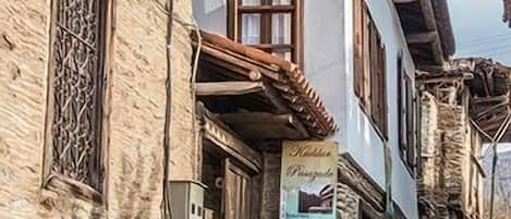 Un edificio de piedra tradicional con un cartel que anuncia una atracción local.