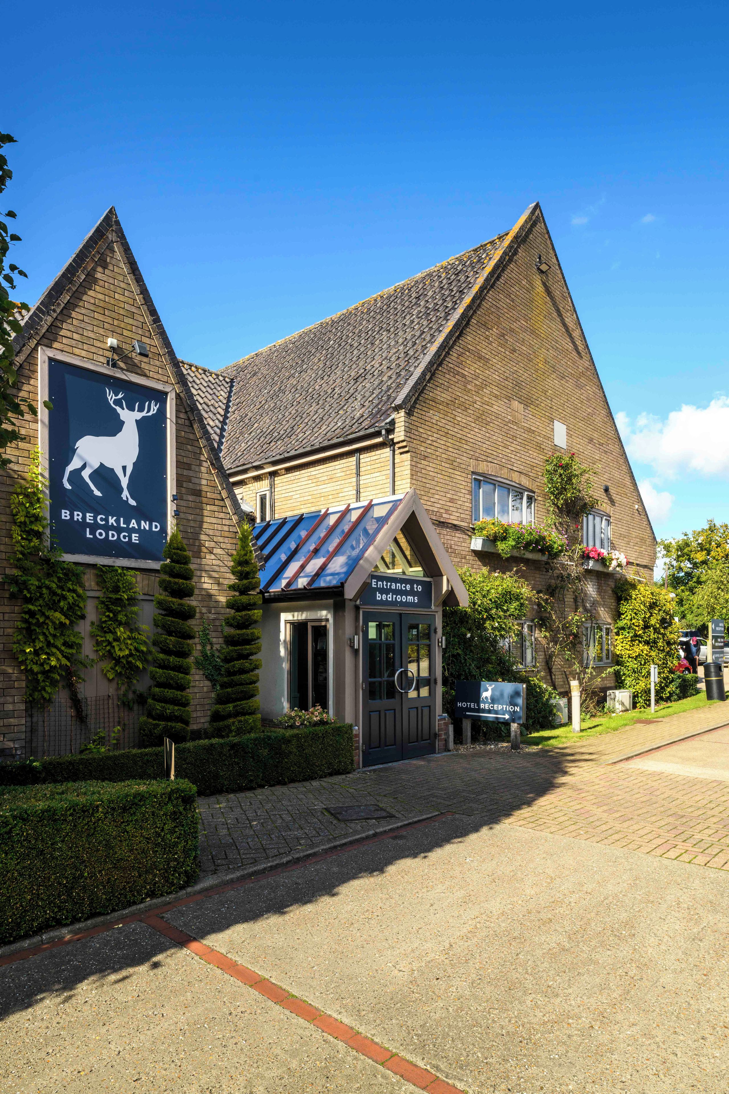 A brick building with a sign for 'Breckland Lodge.'