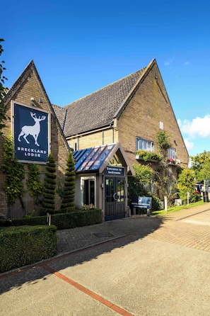 Um edifício de tijolos com uma placa indicando 'Breckland Lodge'.