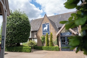 A building with a sign for 'Breckland Lodge' and an entrance to bedrooms. - The Breckland Lodge Attleborough (Attleborough)