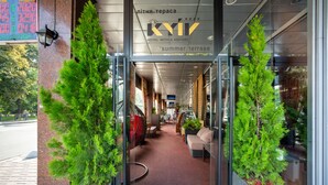Ein Hotel mit Glasfassade, Innenbereich mit Sitzgelegenheiten und Topfpflanzen.