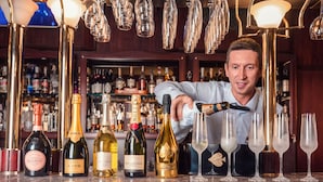 Eine Bar mit verschiedenen Spirituosenflaschen, einem Barkeeper und hängenden Lampen.