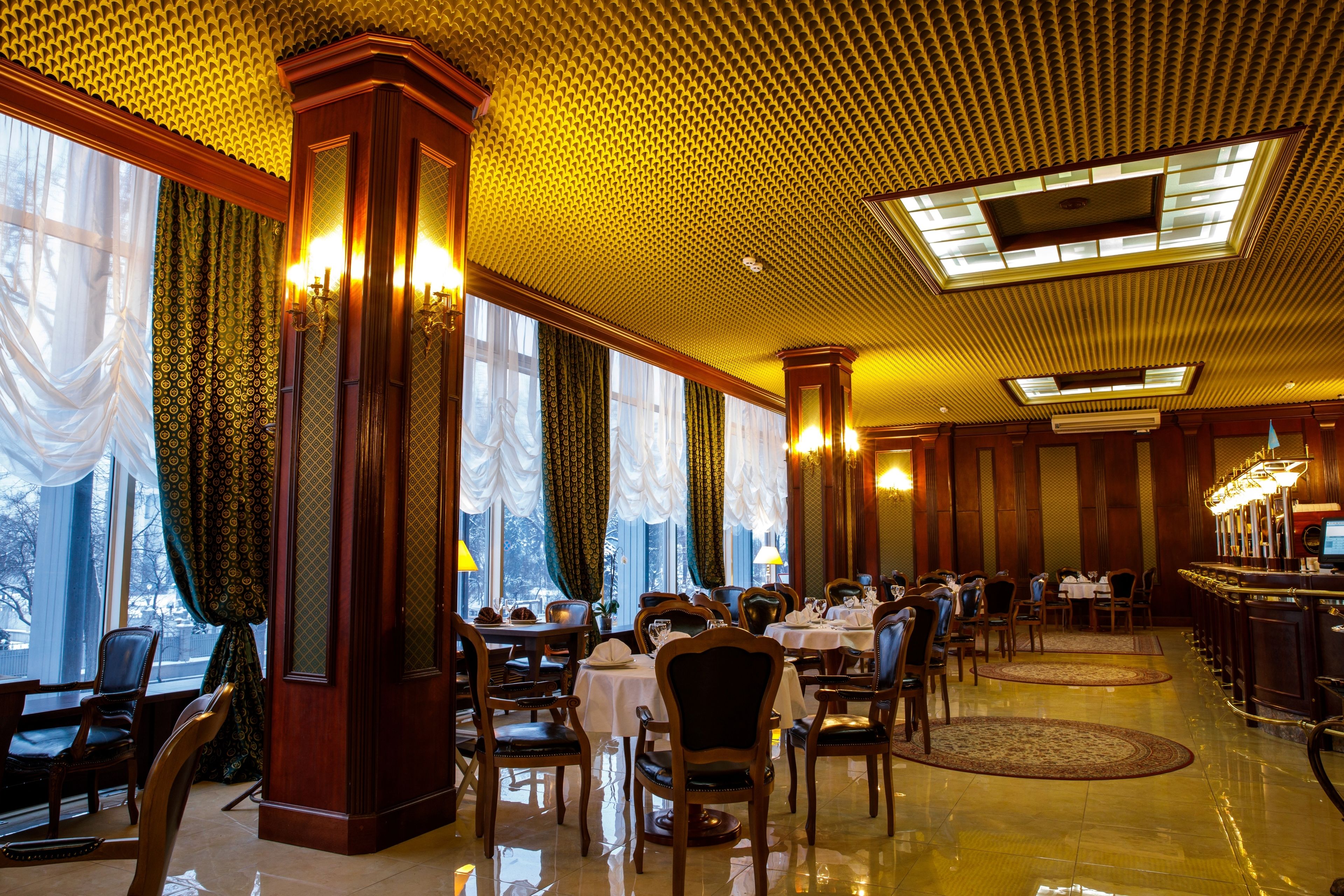 Un espace de restauration dans un hôtel, avec des tables, des chaises et un bar.