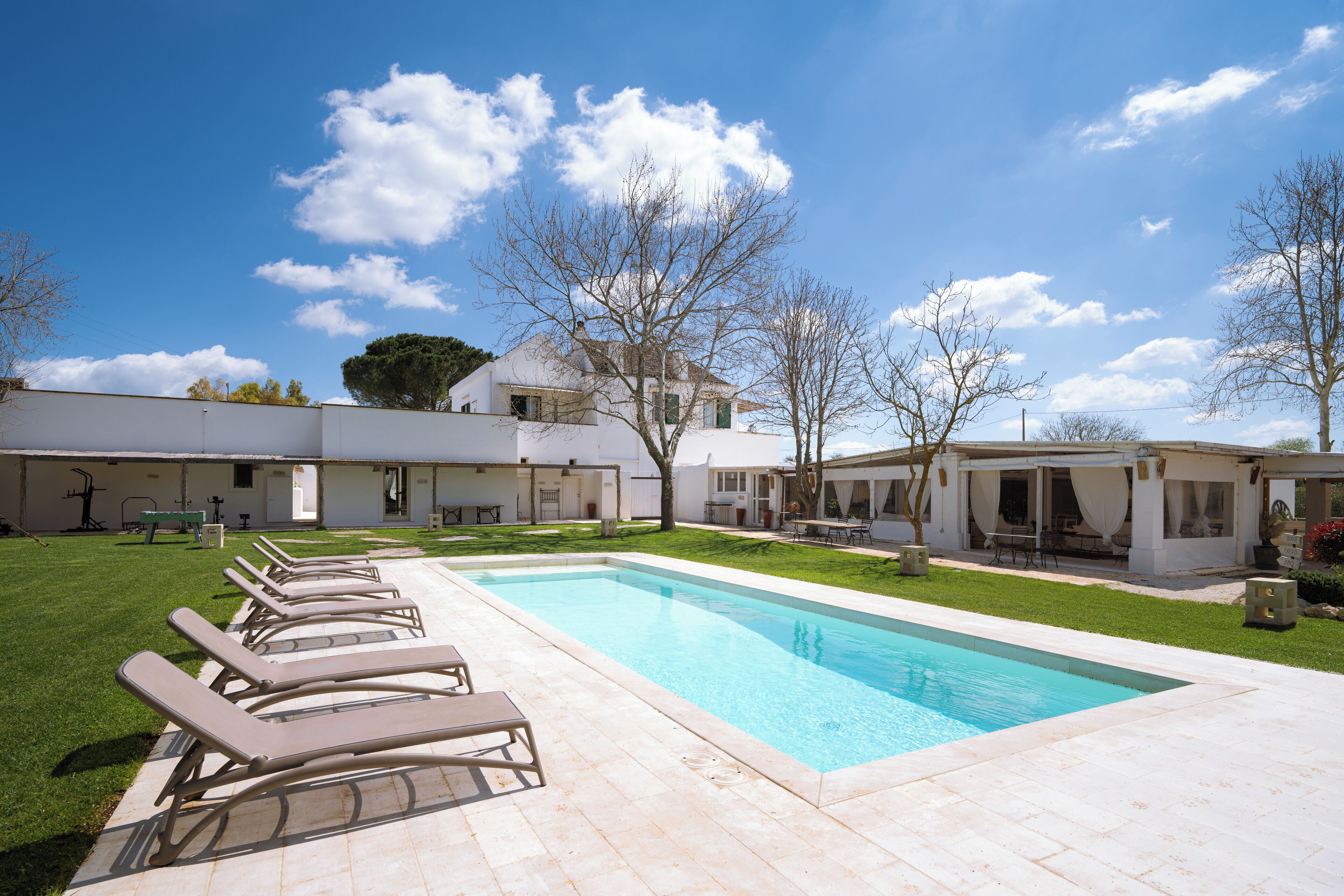 Una piscina al aire libre de temporada, sombrillas