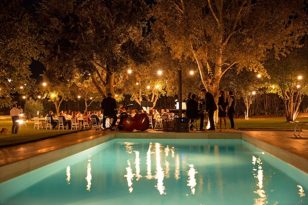 Una piscina al aire libre de temporada, sombrillas, tumbonas