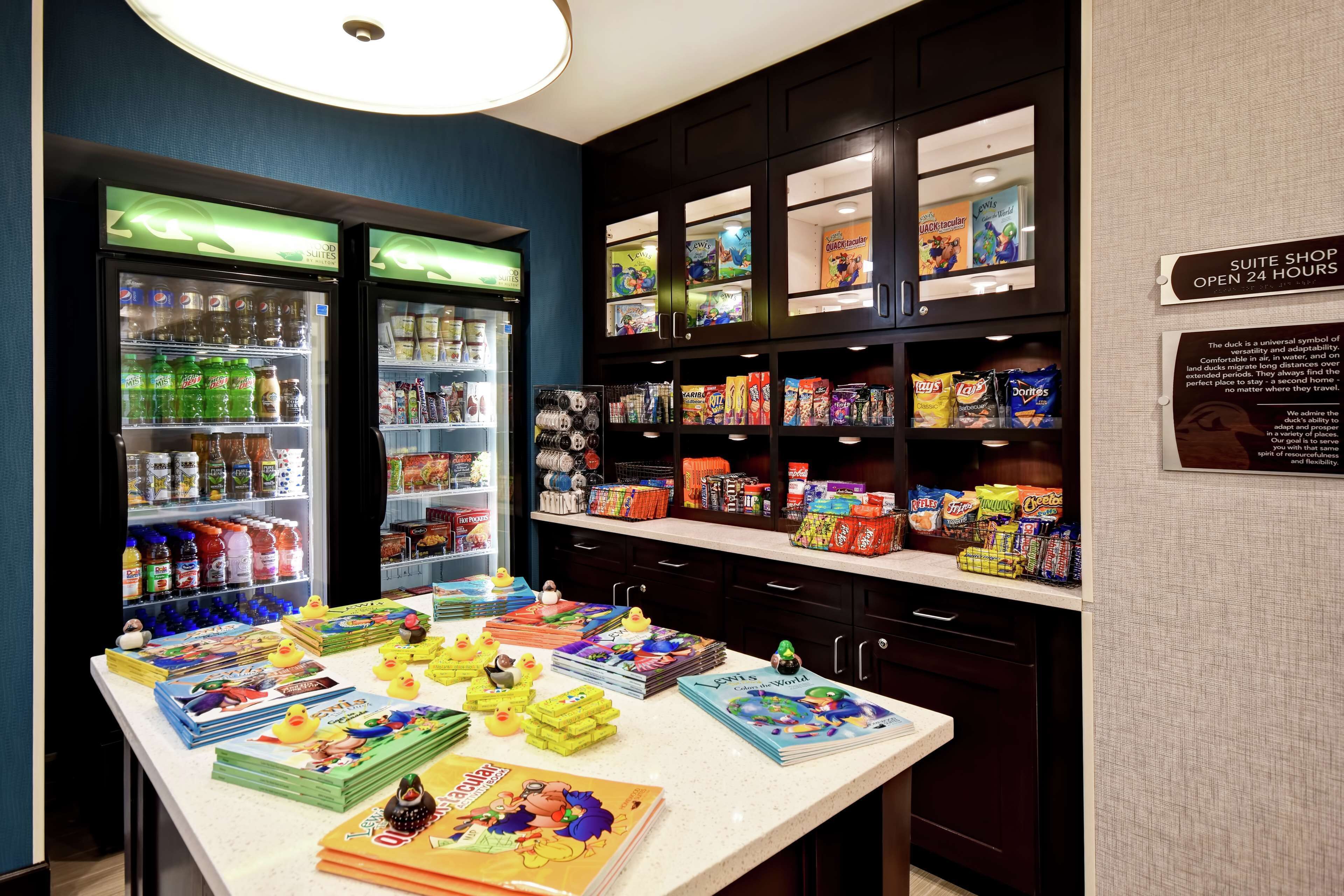 A suite shop with 24-hour access, featuring a variety of snacks, books, and beverages.