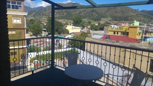 A balcony with a view of a mountainous landscape, a playground, and colorful buildings. - MON Hotel Boutique (Constanza)