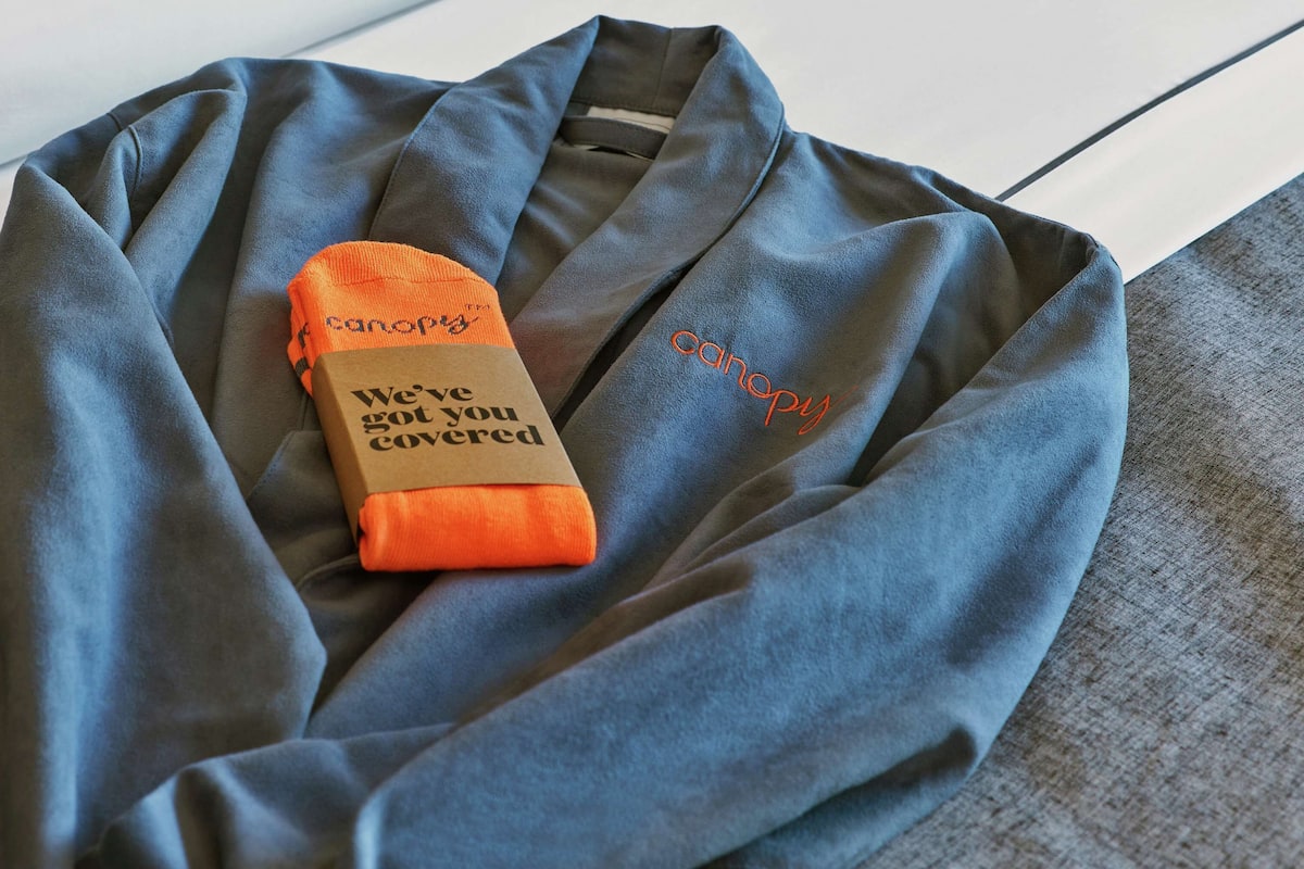 A neatly folded blue garment with a small orange item labeled "canopy" and a message "We've got you covered" on it.