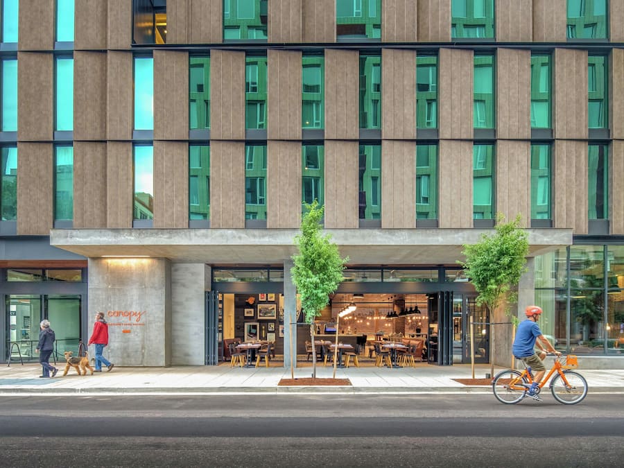 Un edificio moderno con fachada de vidrio y paneles de madera verticales.