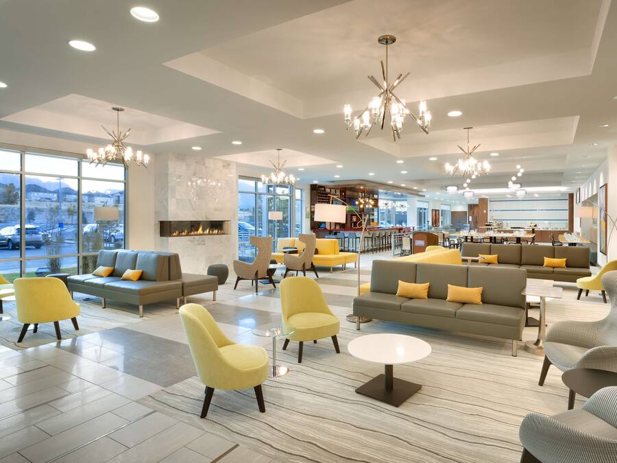 A spacious lobby with seating areas, a fireplace, and a view of the parking lot.